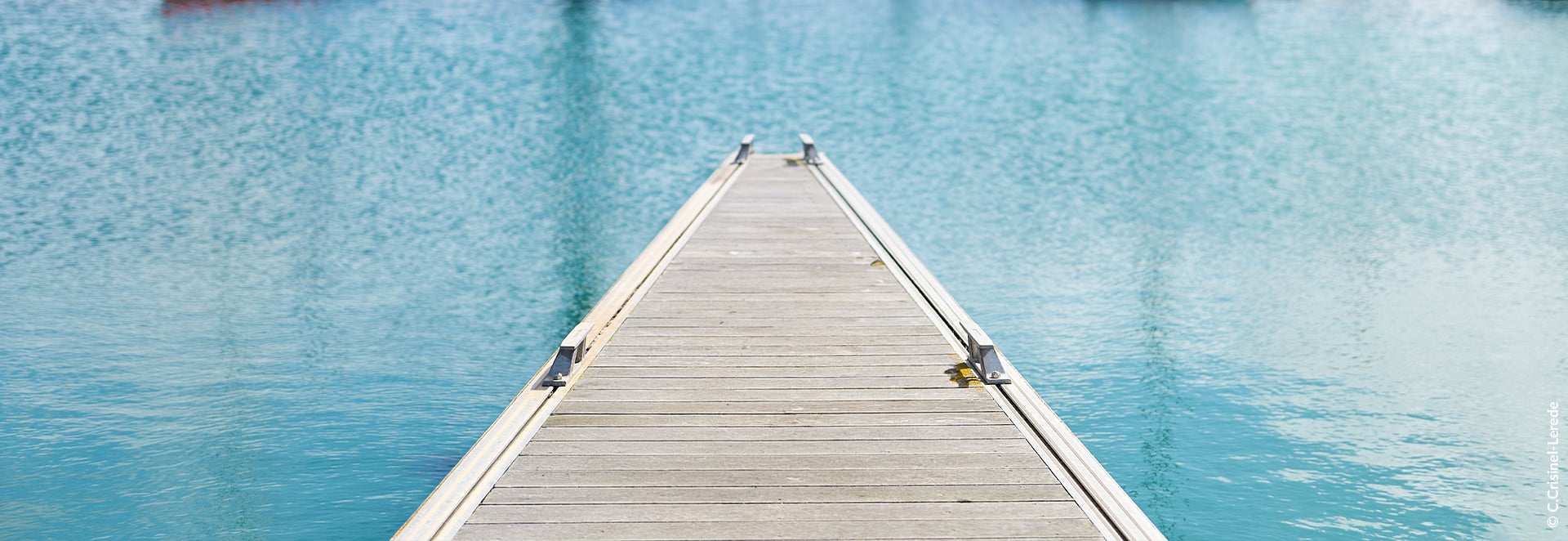 Wooden dock extending into a calm blue body of water